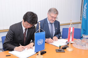 Robert Zeiner and Hiroshi Kuniyoshi signing an agreement.