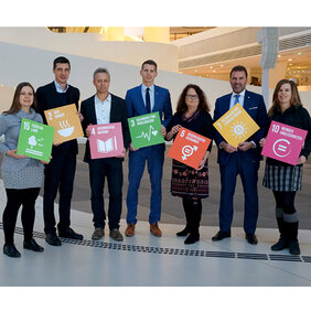 TeilnehmerInnen halten Schilder mit SDG-Zielen.