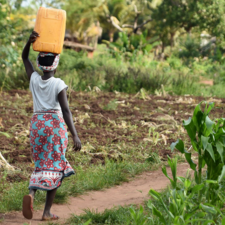 Woman carrying a water can.